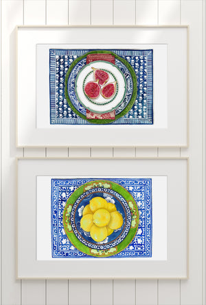 Print of figs on white and green plate with with patterned blue plate and table mat
