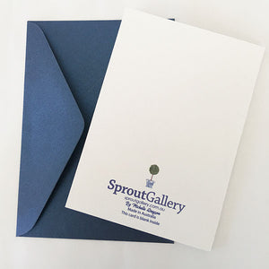 A blue and white card with topiary trees