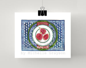 Print of figs on white and green plate with with patterned blue plate and table mat